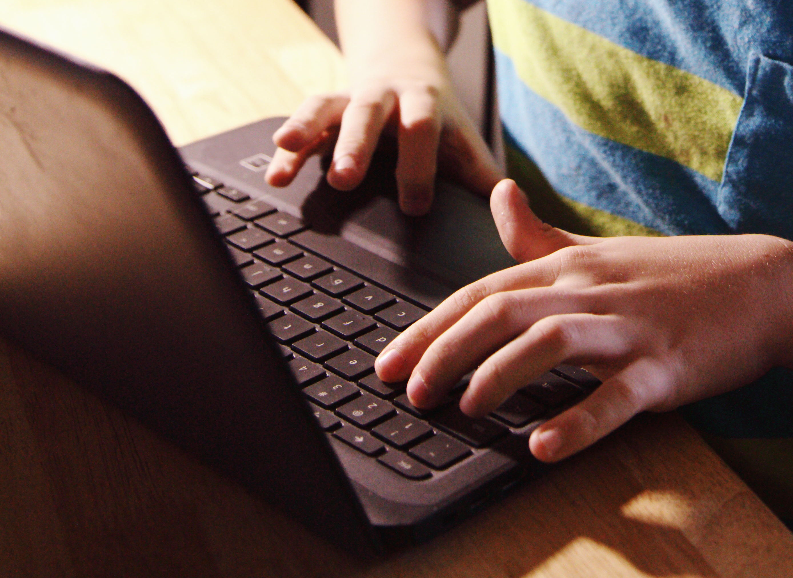 Child typing on a Chromebook.